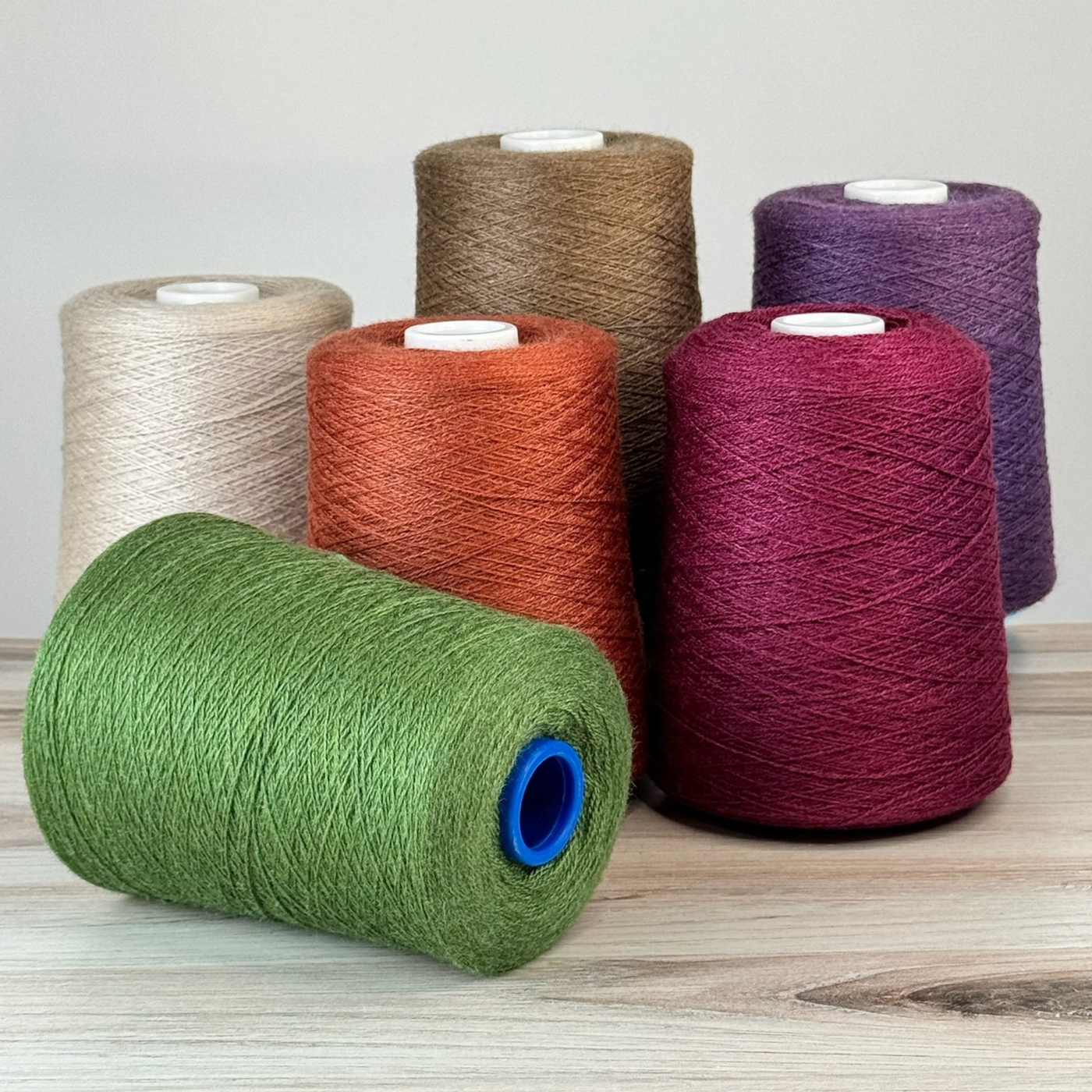 Seaweed cone in front with rust, vanilla, and claret behind; 1 lb. cones, 2/18 lace, 4455 yards—organic palette for rustic weaves.