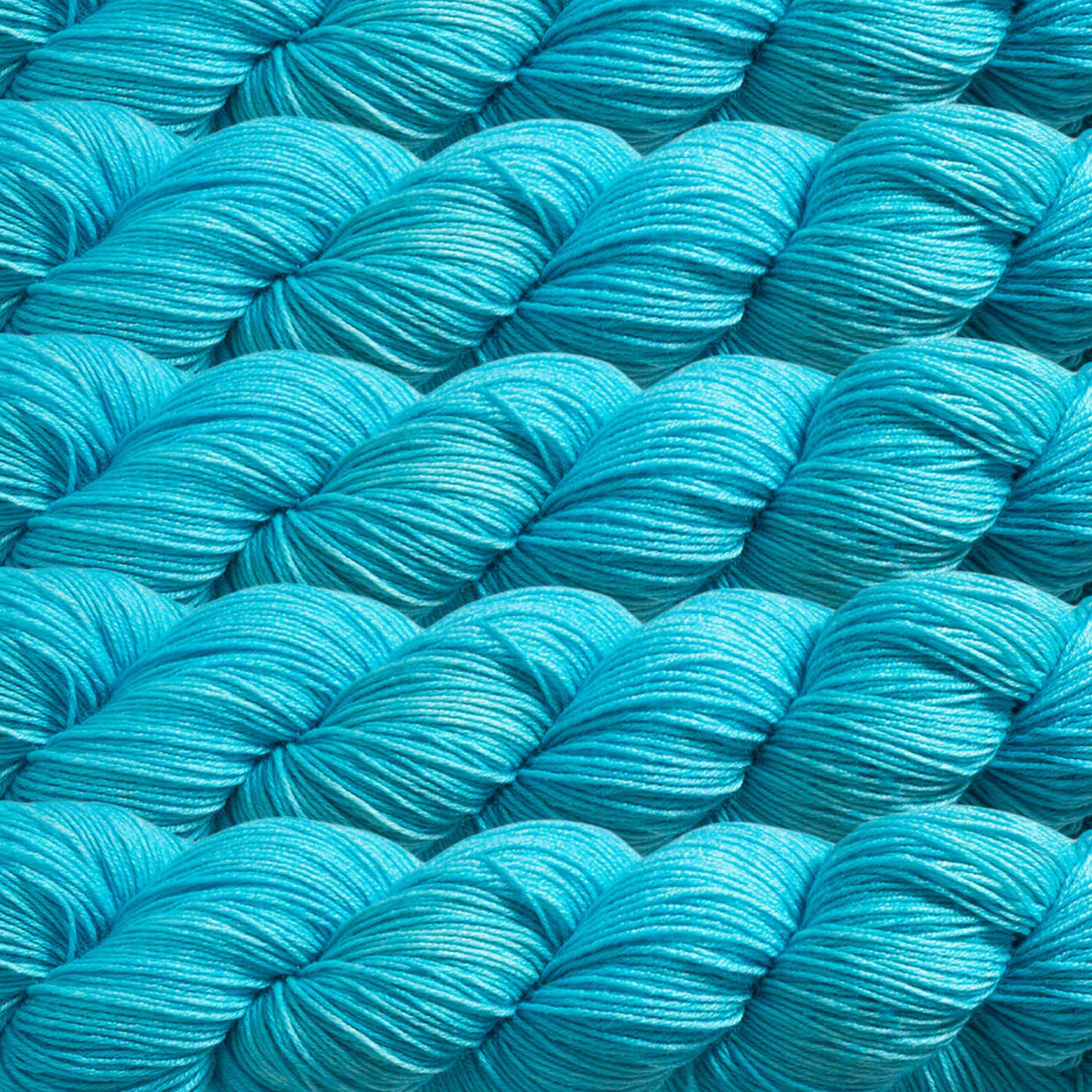 Heritage Yarn in Jamaica Bay (1016), a bright turquoise shade inspired by vibrant tropical waters. Made with a blend of Superwash Merino and Nylon, this fingering-weight yarn is perfect for weaving, knitting, and crocheting eye-catching creations. Available in 1 lb. cones with 1,996 yards for endless crafting possibilities.