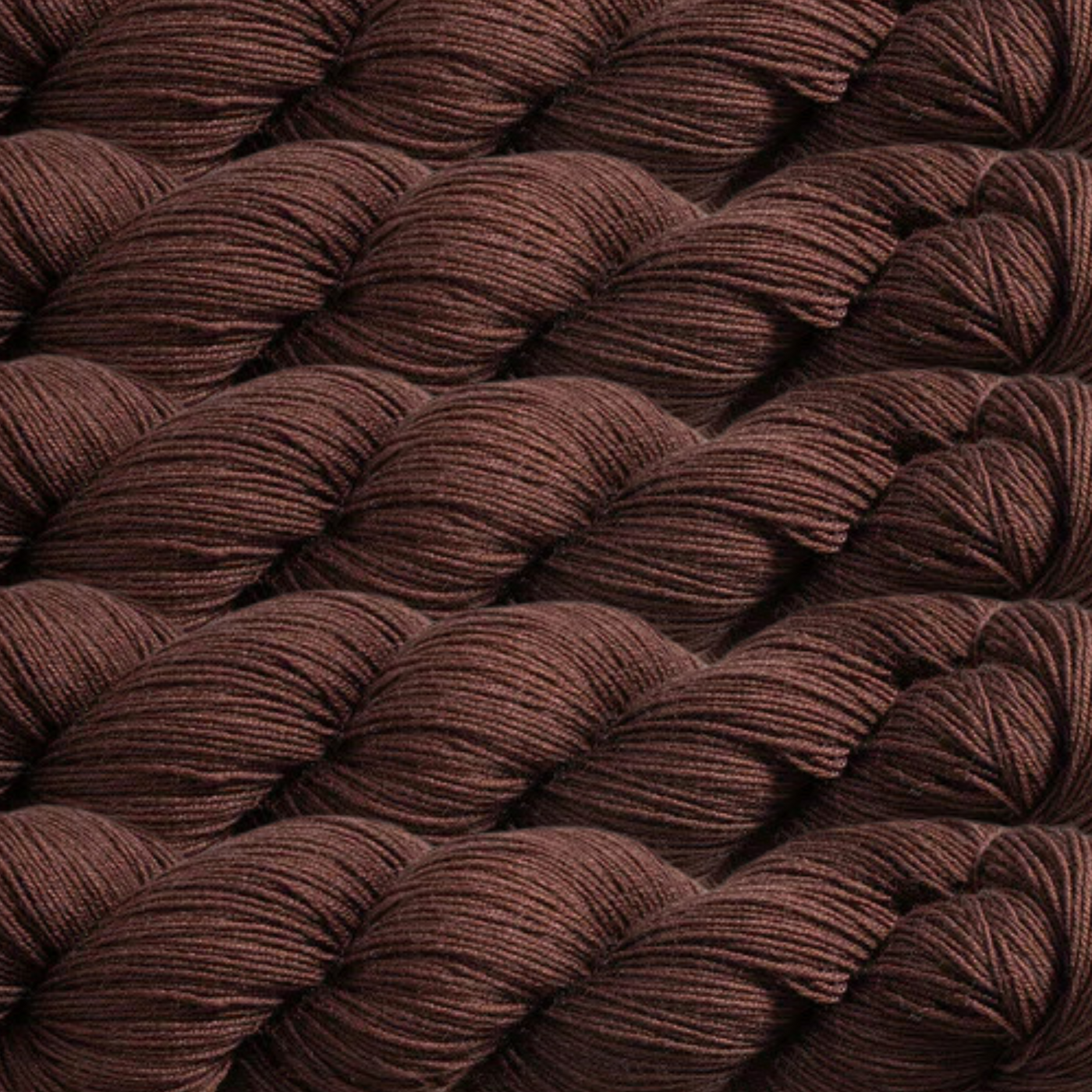 Heritage Yarn in Dark Walnut, a rich and earthy brown shade reminiscent of natural wood tones. Made from a durable Superwash Merino and Nylon blend, this fingering-weight yarn is perfect for knitting, crocheting, and weaving. Offered in 1 lb. cones with 1,996 yards for endless creative projects.