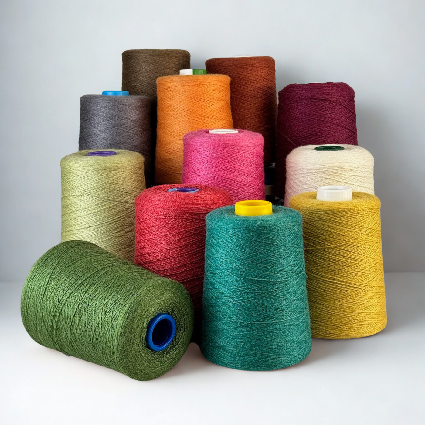 Seaweed cone leads a pyramid of vivid colors on wood; 1 lb. cones, 2/18 lace (4455 yards), lustrous blend ideal for warp stripes.