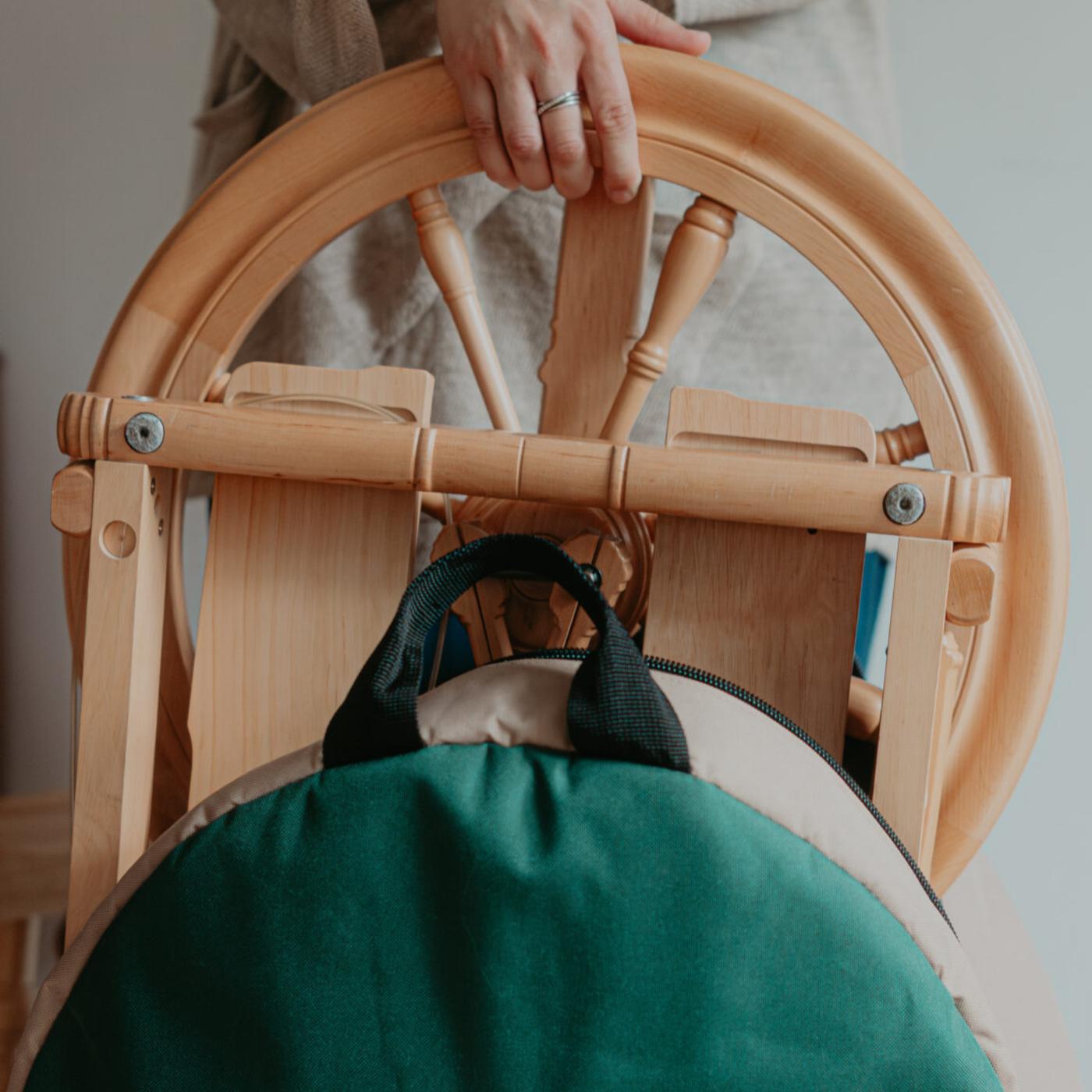 Close-up of Kromski Sonata Encore being lifted into a backpack carry bag, highlighting the wheel’s fold-flat portability.