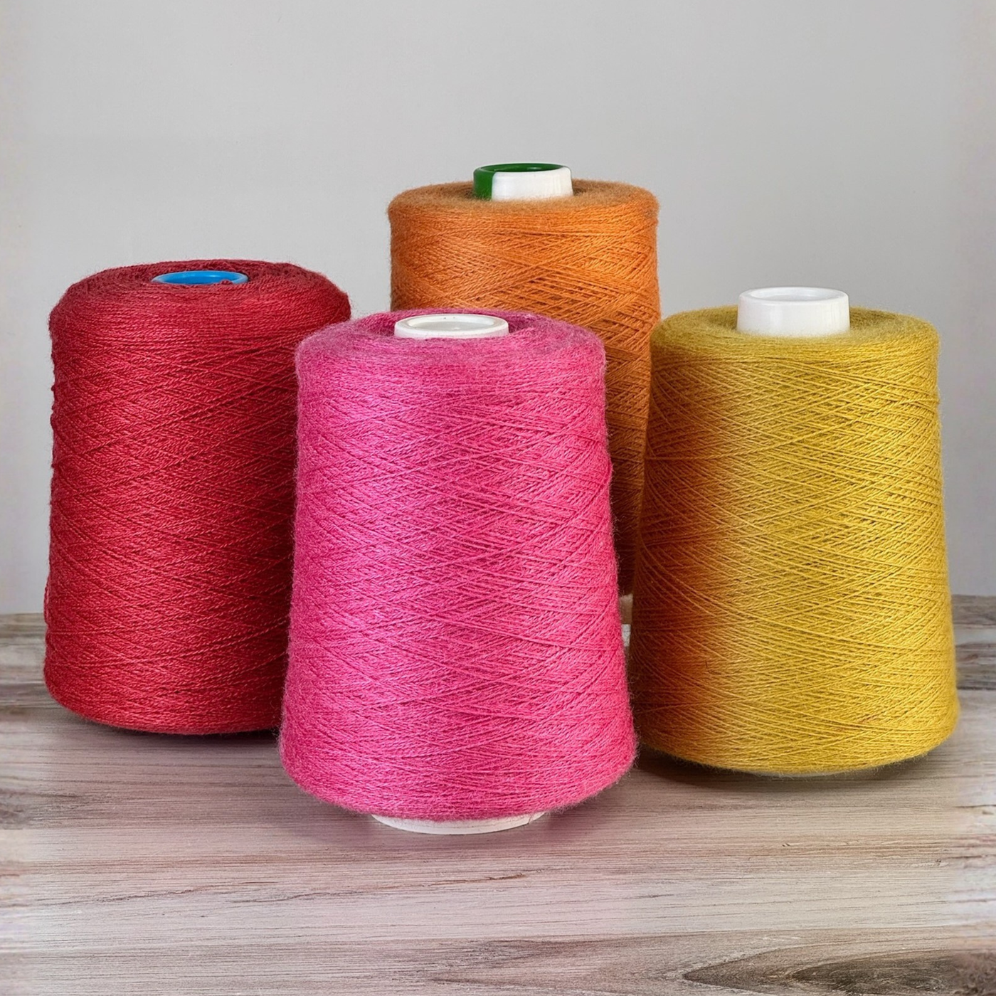 Bold red, orange, and sunflower cones grouped on wood; 1 lb. cones, 2/18 lace, 4455 yards—luminous sheen for statement shawls.