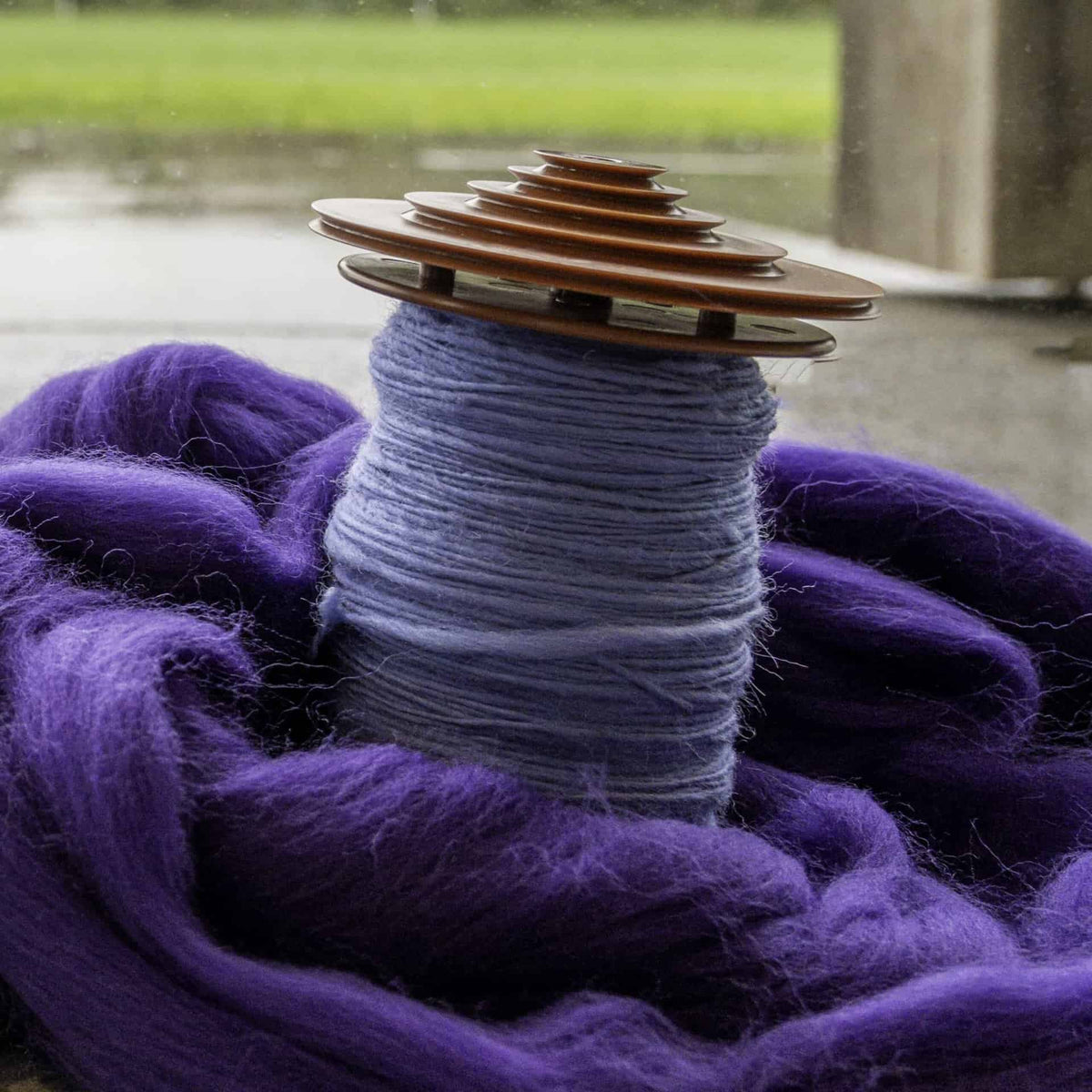 A lojan bobbin with freshly spun blue yarn on it.