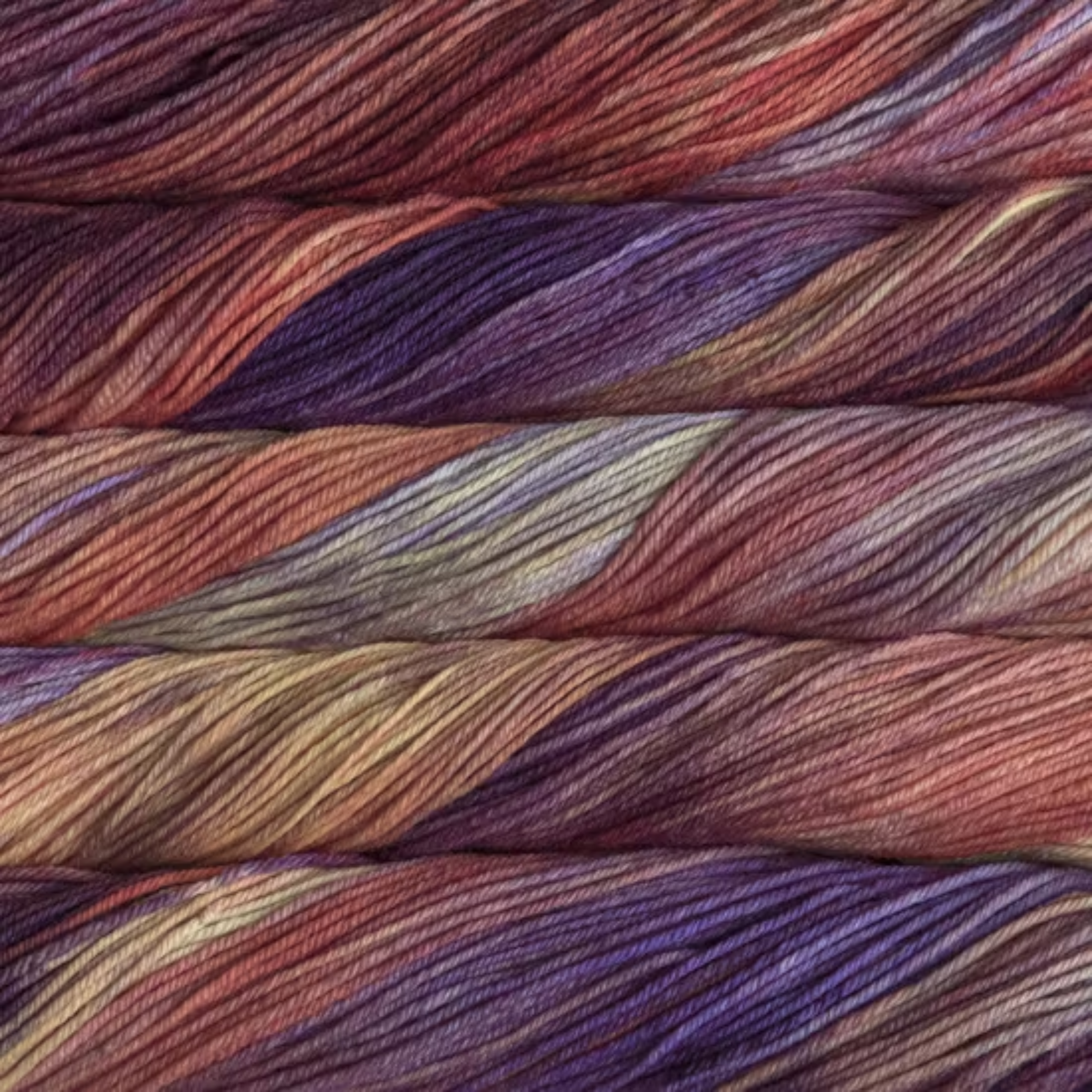 Malabrigo Rios hand-dyed merino superwash worsted weight yarn in the color Archangel RIO850, a tonal blend of peach, blush pink, rose, violet, and pale yellow.