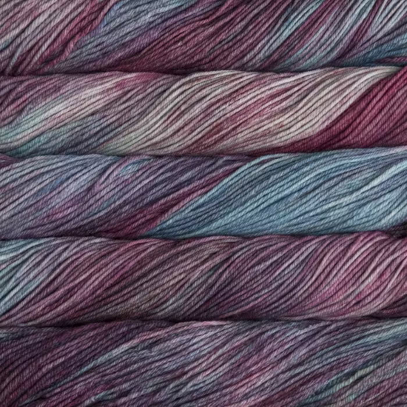Malabrigo Rios hand-dyed merino superwash worsted weight yarn in the color Lotus RIO120, a tonal blend of pale blue, pink, rose, and purple.