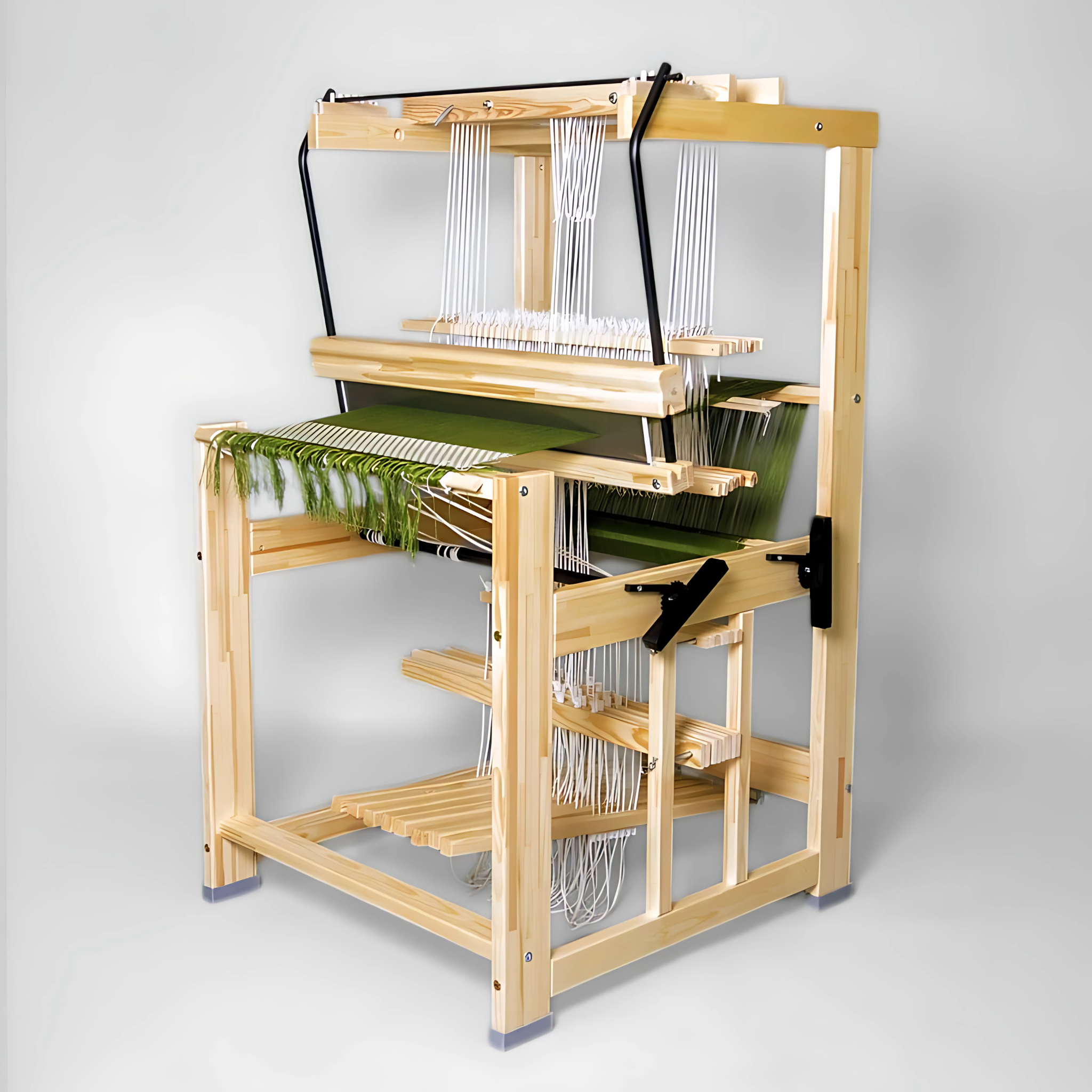 Glimakra Julia Floor Loom in natural wood finish with green warp threads. A compact and versatile loom offering counterbalance and countermarch configurations, ideal for small spaces and high-quality textile weaving.