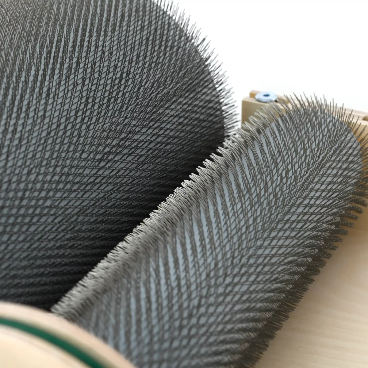 Close-up of the Golden Fleece WIDE 54 TPI drum carder showing the coarse carding cloth on the main drum and licker-in.