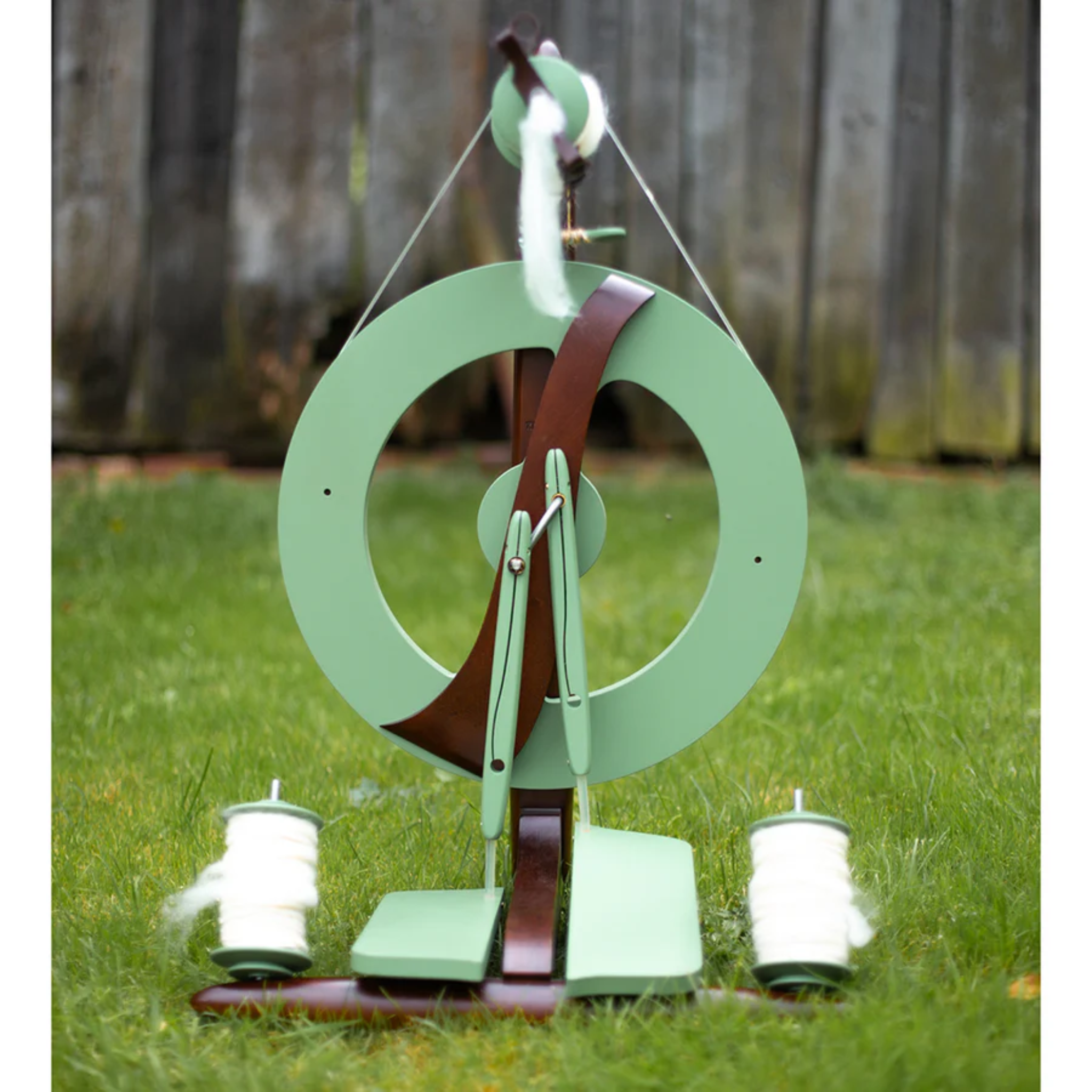 The beautiful limited edition meadow green kromski fantasia spinning wheel in an outdoor setting. 