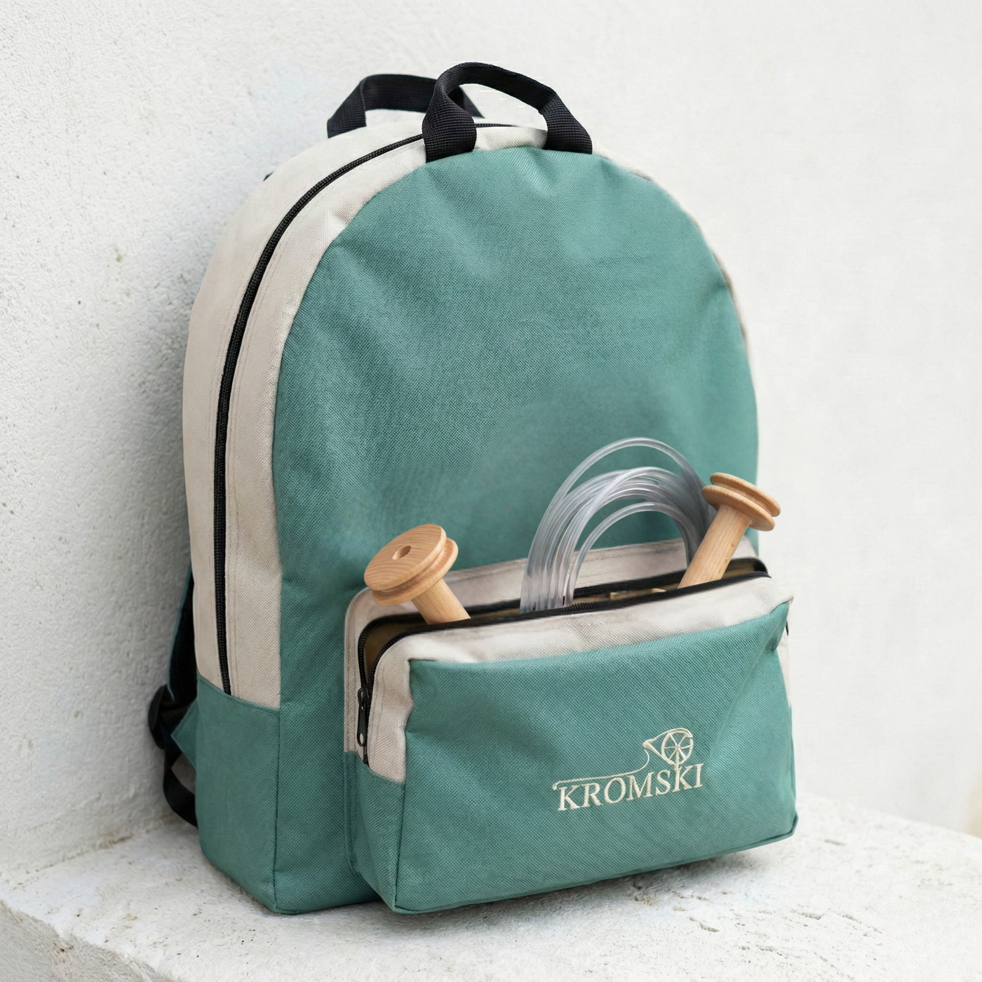Kromski Sonata spinning wheel bag with front pocket open showing bobbins and a spare drive band for travel-ready spinning wheel storage.