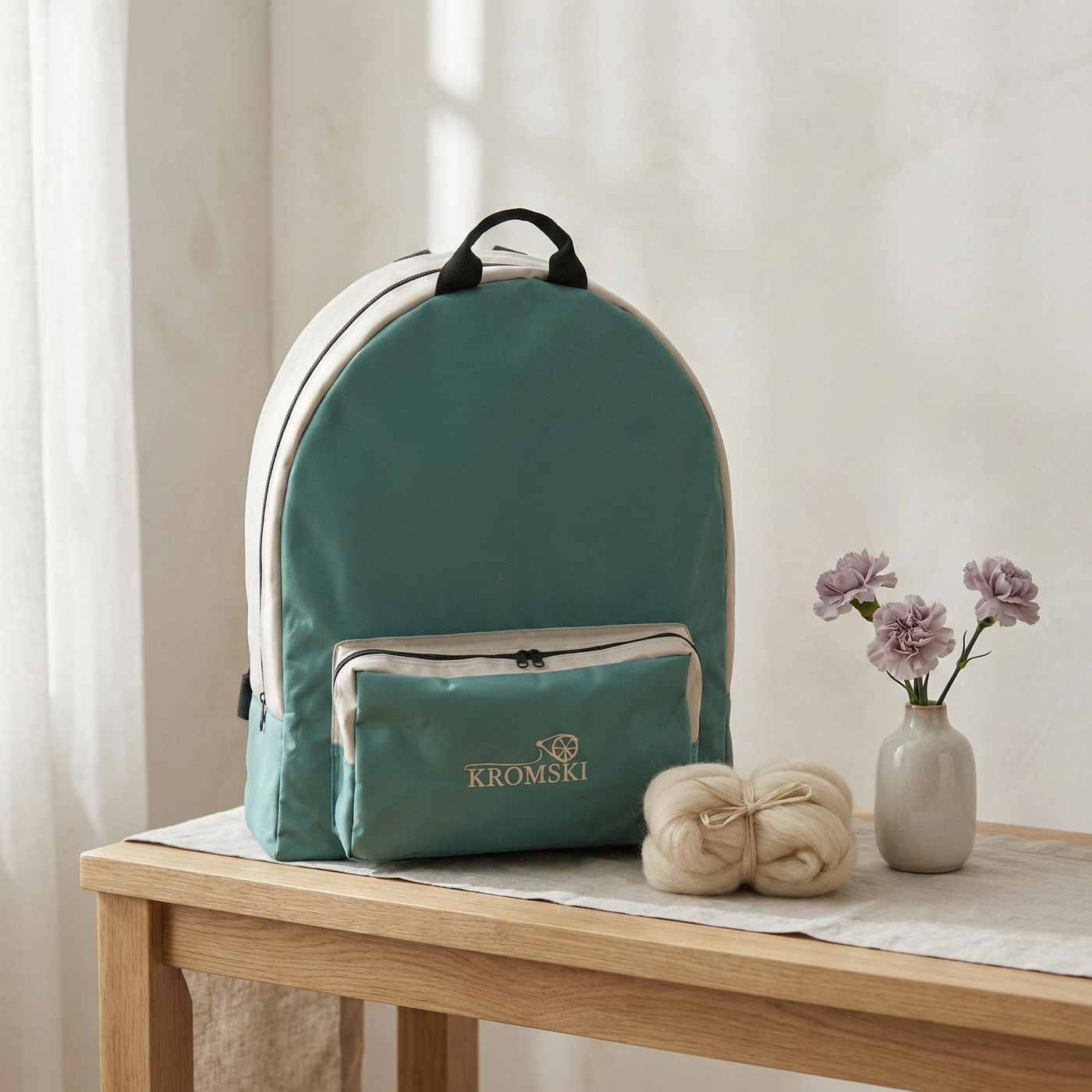 Lifestyle photo of the Kromski Sonata Bag on a table in a bright home studio setting, padded travel bag for the folded spinning wheel.