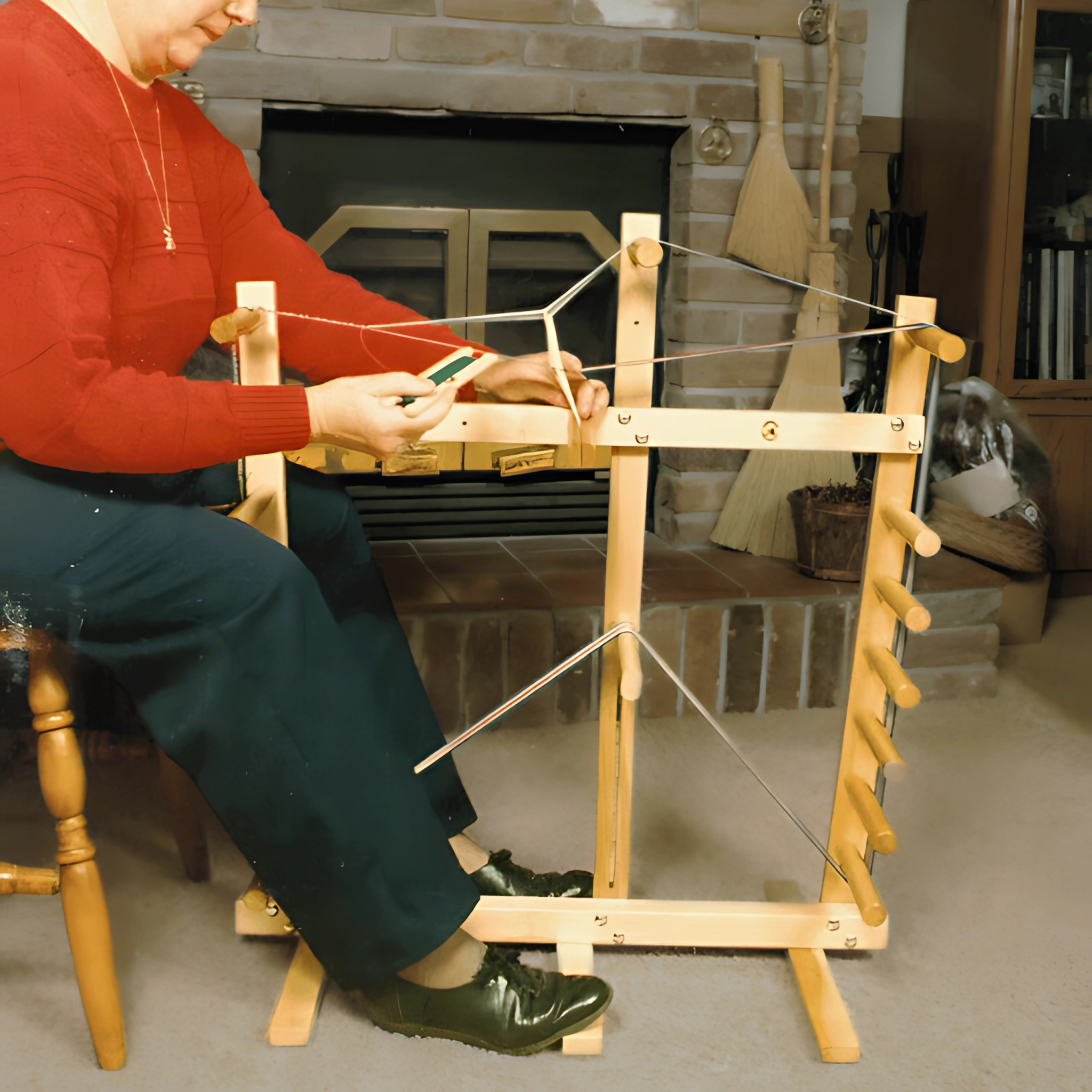 Weaver using the Leclerc Cendrel Inkle Loom – A wooden inkle loom in use, demonstrating warp setup and band weaving for belts, straps, and decorative trim. Ideal for beginner and advanced weavers, featuring a dual-purpose design as both a warping frame and inkle loom.