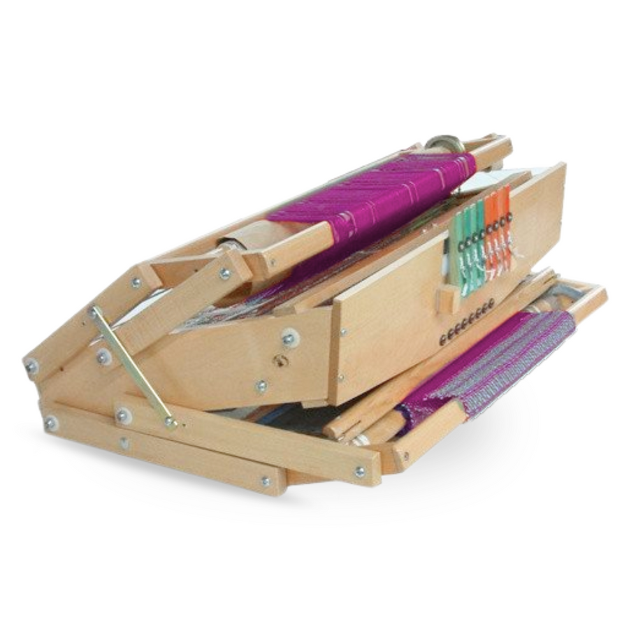 Leclerc Voyageur Table Loom in folded position with vibrant woven fabric, compact design, and color-coded front-mounted levers. A portable, space-saving multi-shaft loom ideal for workshops, travel, and home studios.