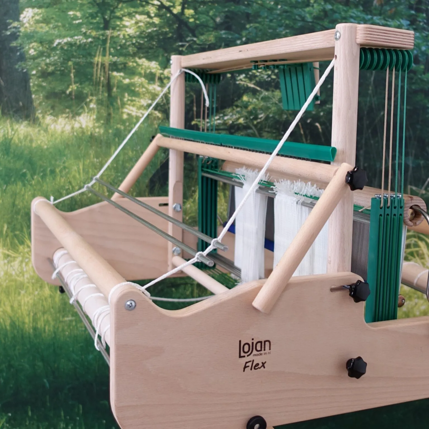 Lojan Raddle Flex mounted across the top of a Lojan Flex table loom, front three-quarter view showing warp spread for even beaming.