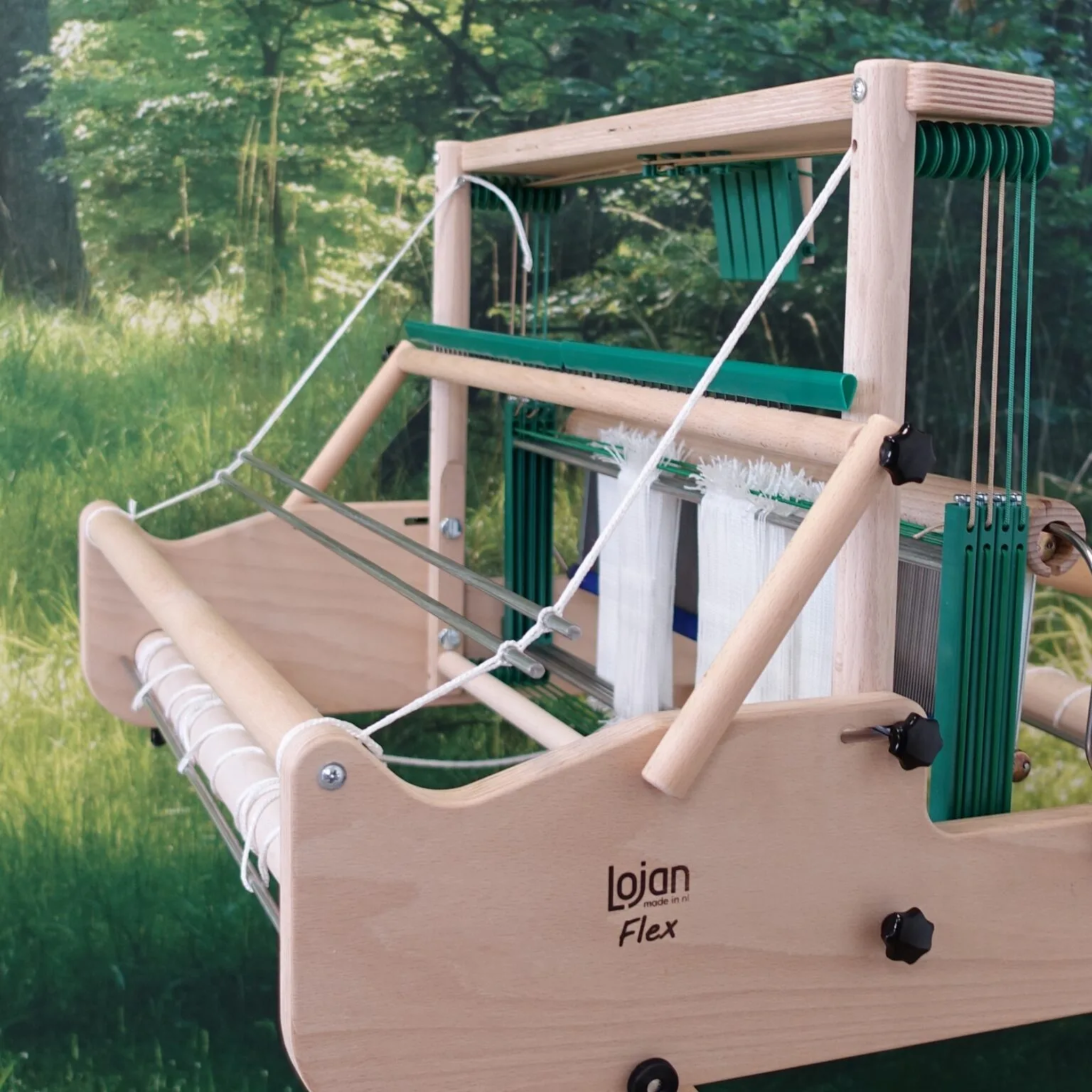 Lojan Raddle Flex mounted across the top of a Lojan Flex table loom, front three-quarter view showing warp spread for even beaming.