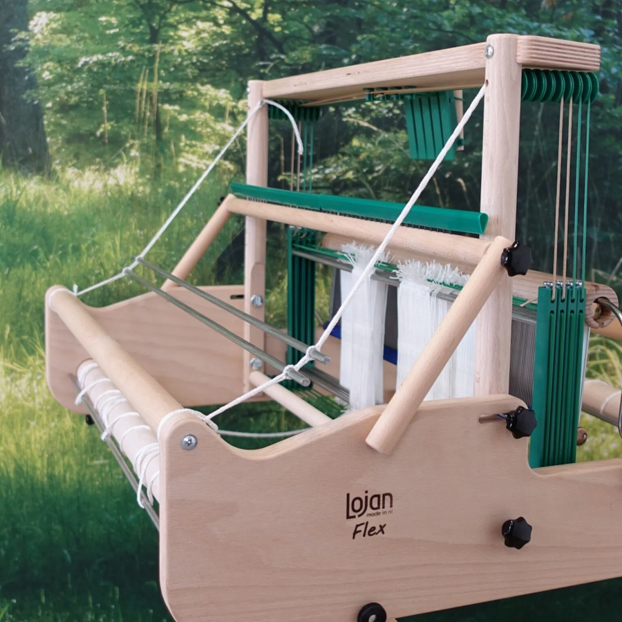 Lojan Raddle Flex mounted across the top of a Lojan Flex table loom, front three-quarter view showing warp spread for even beaming.