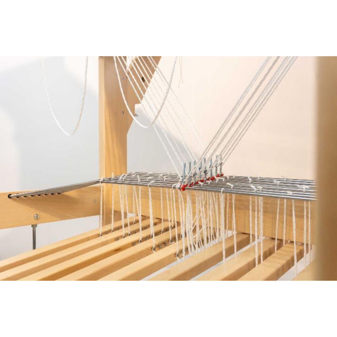 Close view of the treadles and tie up cords attached to the tension bars on the Louet David III floor loom.
