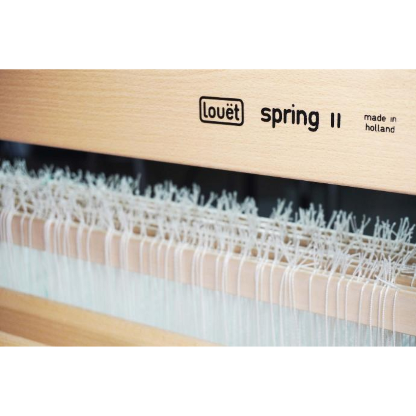 Louët Spring II engraved logo on castle, illustrating solid beech construction and lacquer finish
