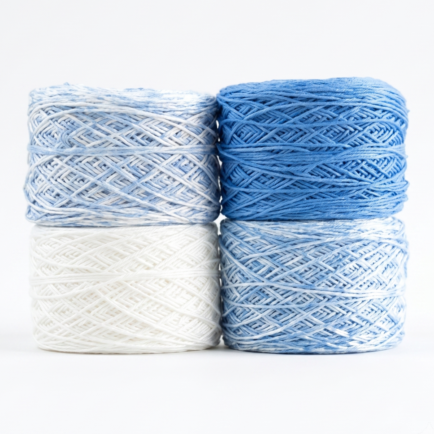 Revolution Fibers Baby Bloom Gradient Baby Blanket Kit Heron Lake yarn cakes in white, blue speckle, and solid blue.