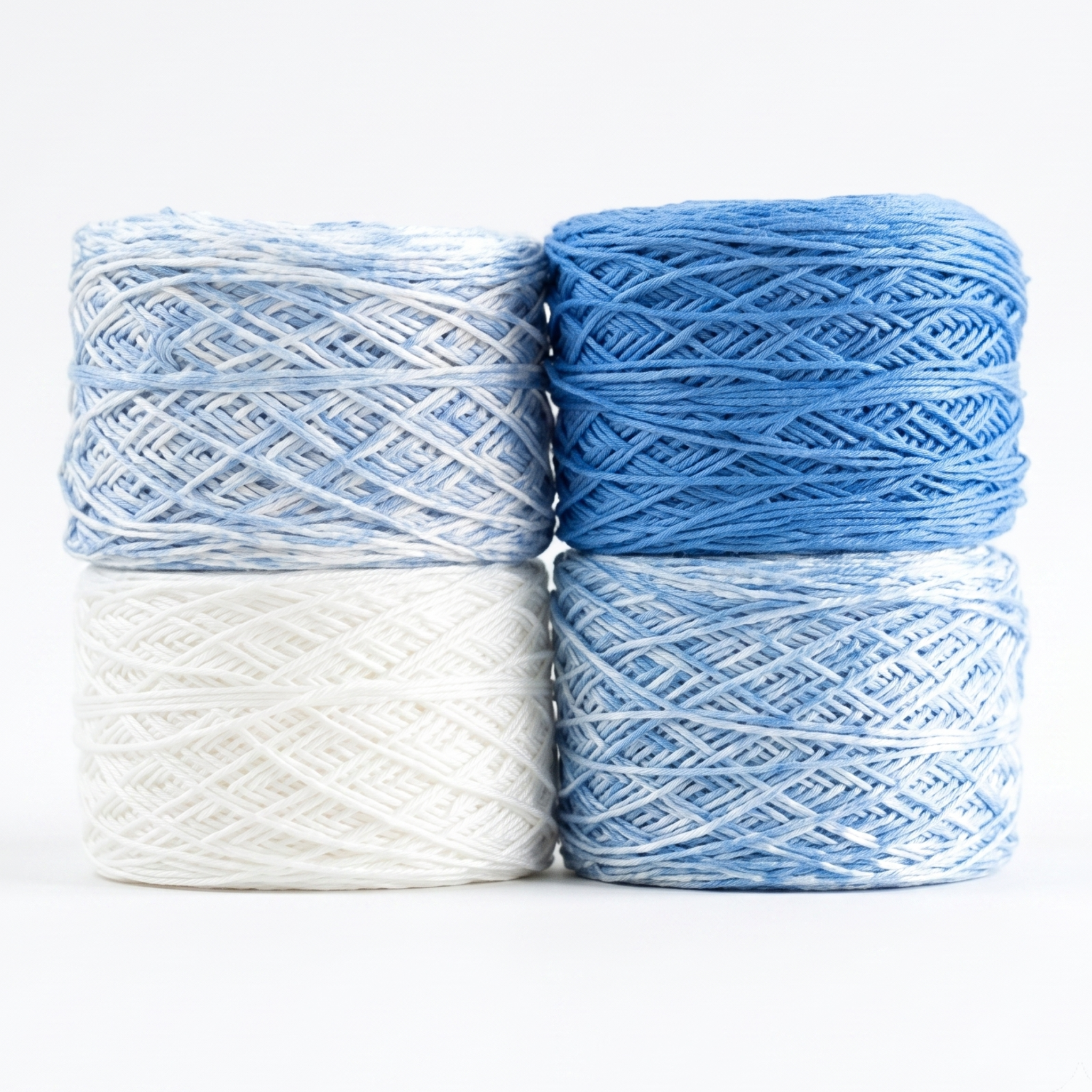 Revolution Fibers Baby Bloom Gradient Baby Blanket Kit Heron Lake yarn cakes in white, blue speckle, and solid blue.