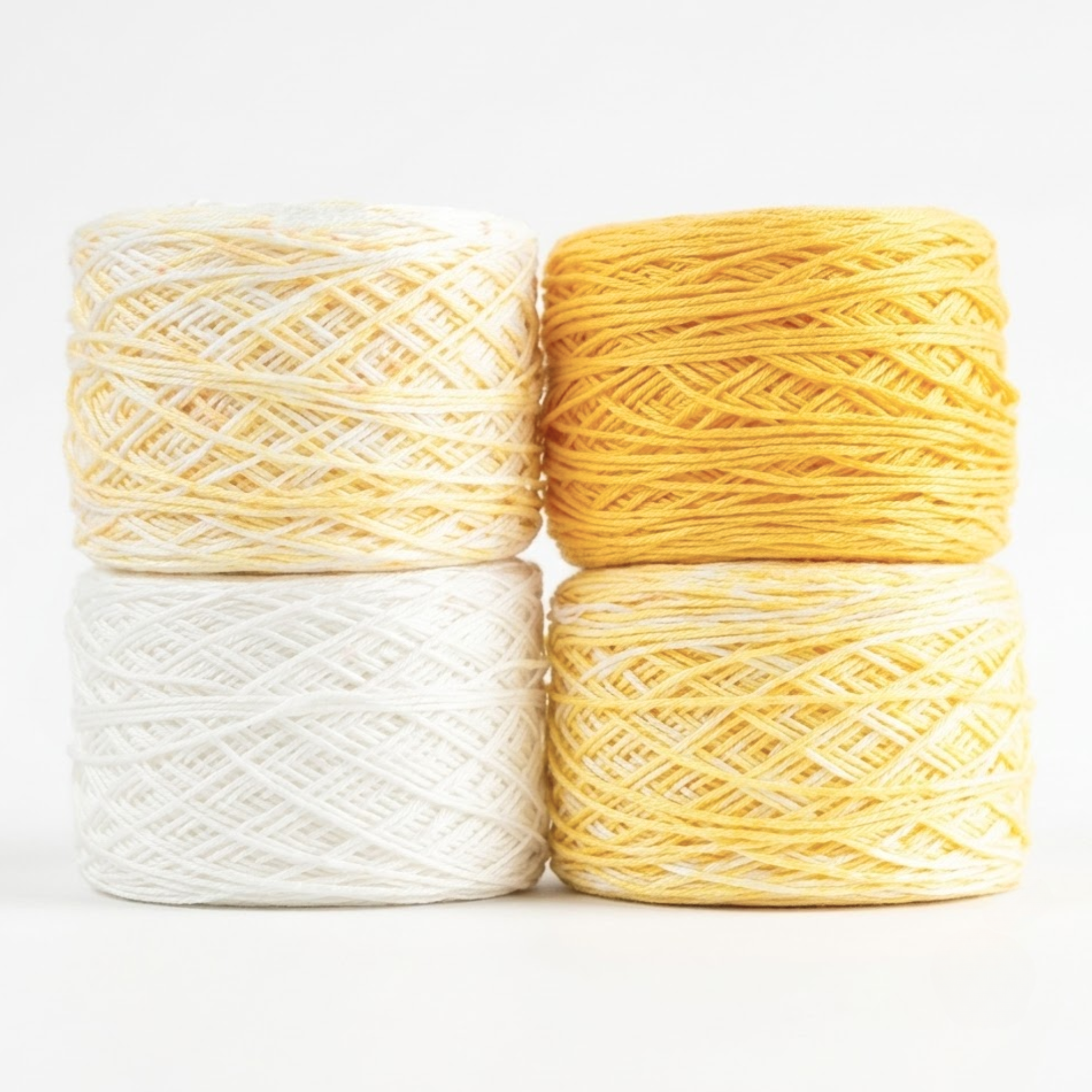 Revolution Fibers Baby Bloom Gradient Baby Blanket Kit Honey Bees yarn cakes in white, yellow speckle, and gold.