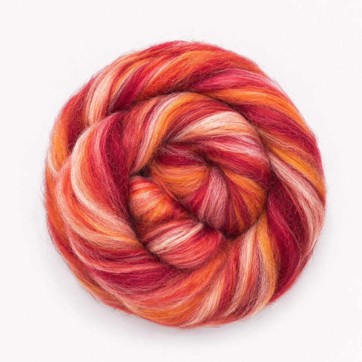 A studio view of Revolution Fibers Bambino Range Roving in Bonnie Bee, featuring saturated red, coral, orange and soft peach fiber.