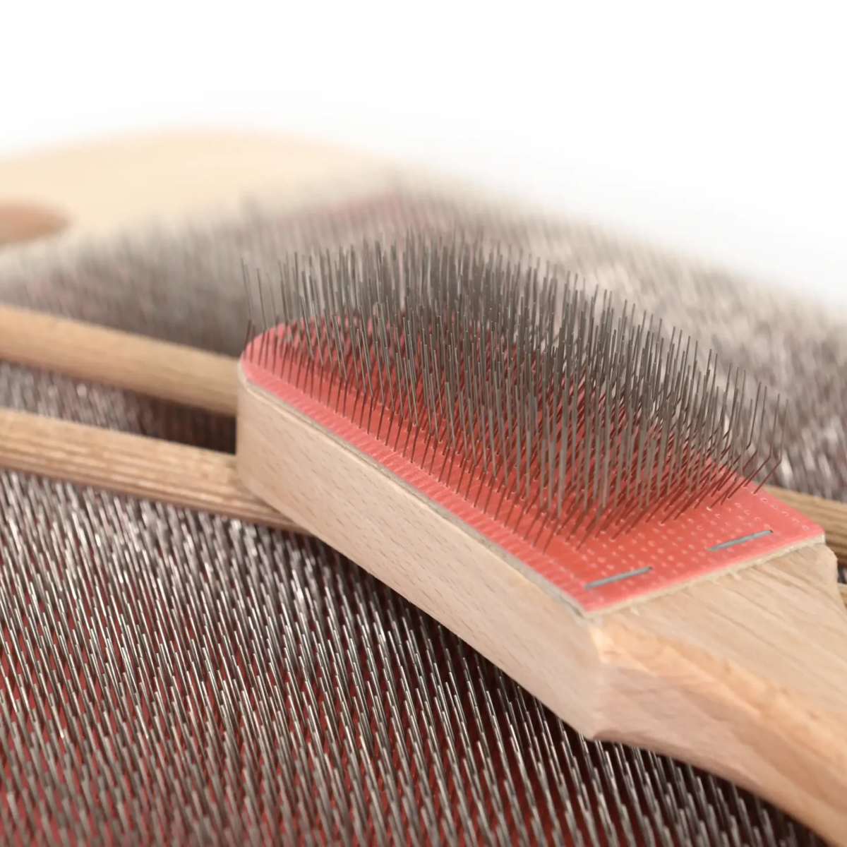Close-up of the blending brush on the Revolution Fibers 108 TPI Blending Board with red carding cloth.