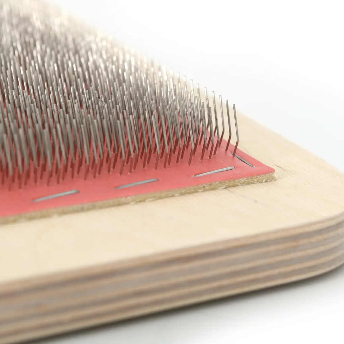 Close-up of the Revolution Fibers 108 TPI Blending Board showing dense carding teeth, red cloth, and layered wood edge.