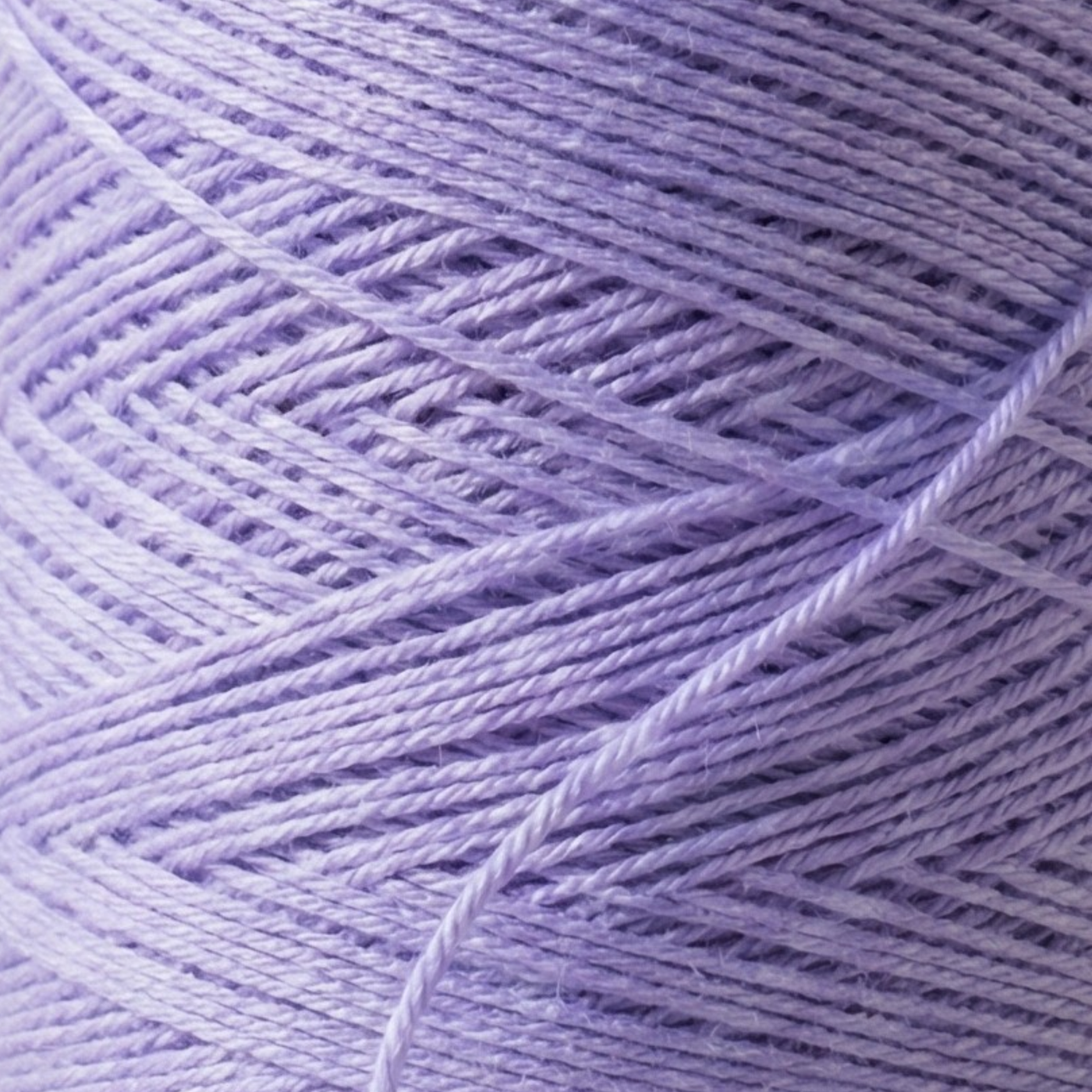 Close-up macro photo of Heritage worsted cone yarn showing winding texture and strand detail for stitch definition and weaving performance.