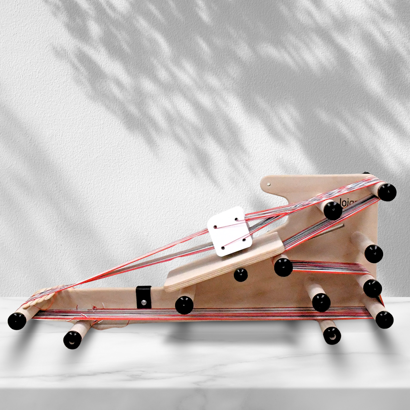 Side view of the Lojan 3-in-1 Inkle Loom by Revolution Fibers, fully warped and ready for band weaving, showing adjustable pegs and stable construction for weaving long and short bands or tablet weaving projects.