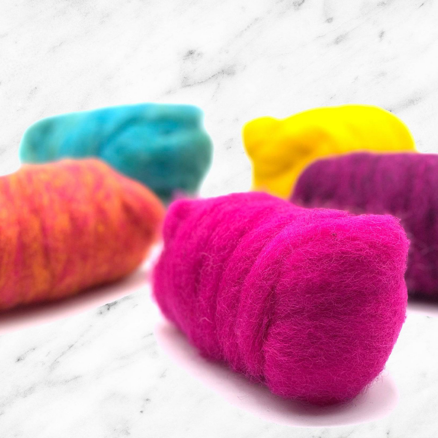 Angled view of Retro Pop Carded Corriedale Wool Sliver Variety Pack by Revolution Fibers – five bright fiber rolls for colorful felting and spinning crafts