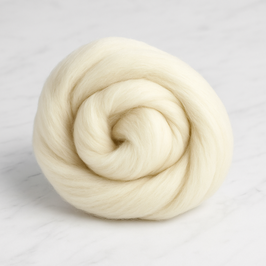 Revolution Fibers Targhee wool combed top coiled bundle on white marble background, soft cream undyed fiber for spinning, felting, and dyeing.