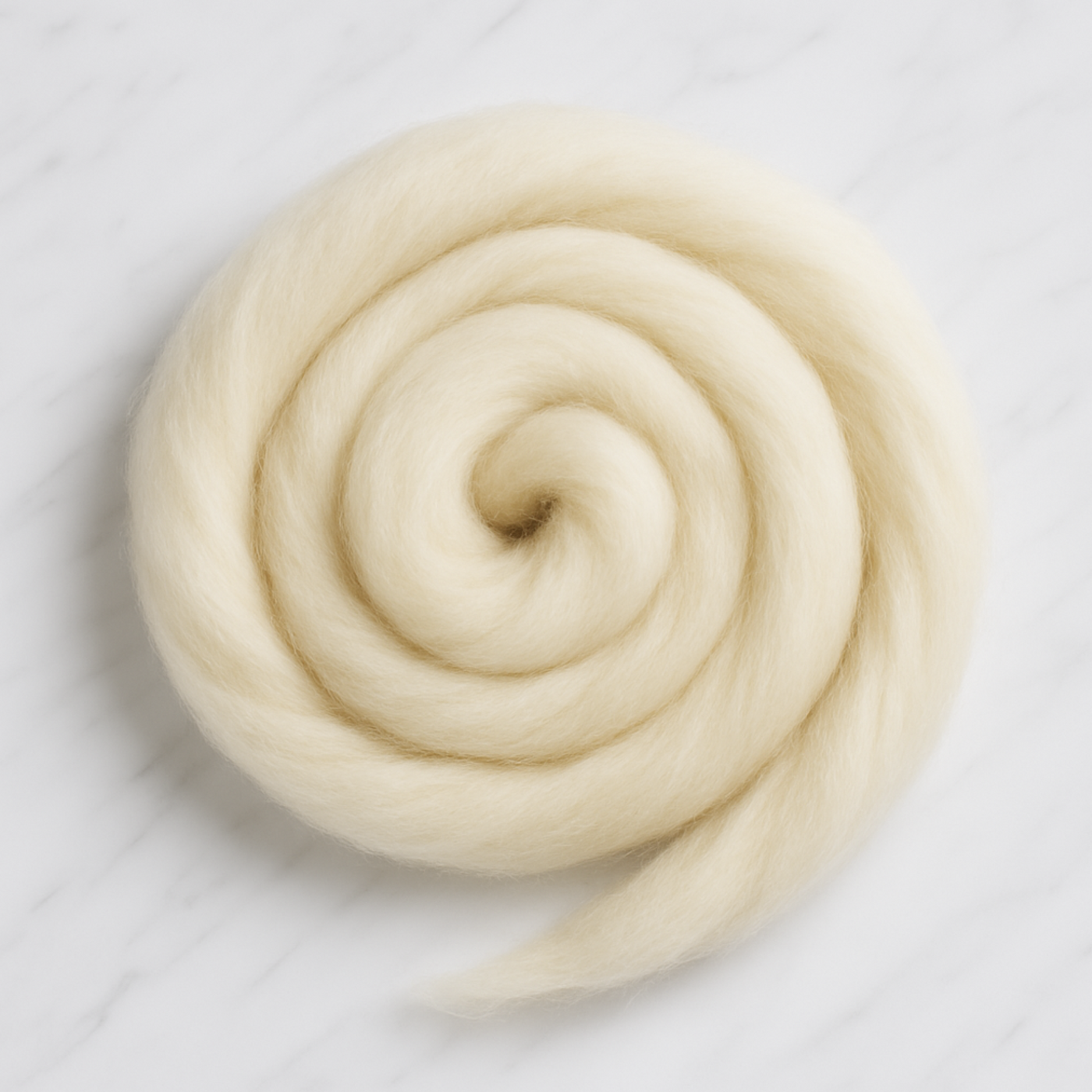 Overhead view of Revolution Fibers Targhee wool combed top spiral coil, undyed cream fiber with lofty matte finish for spinning and felting projects.