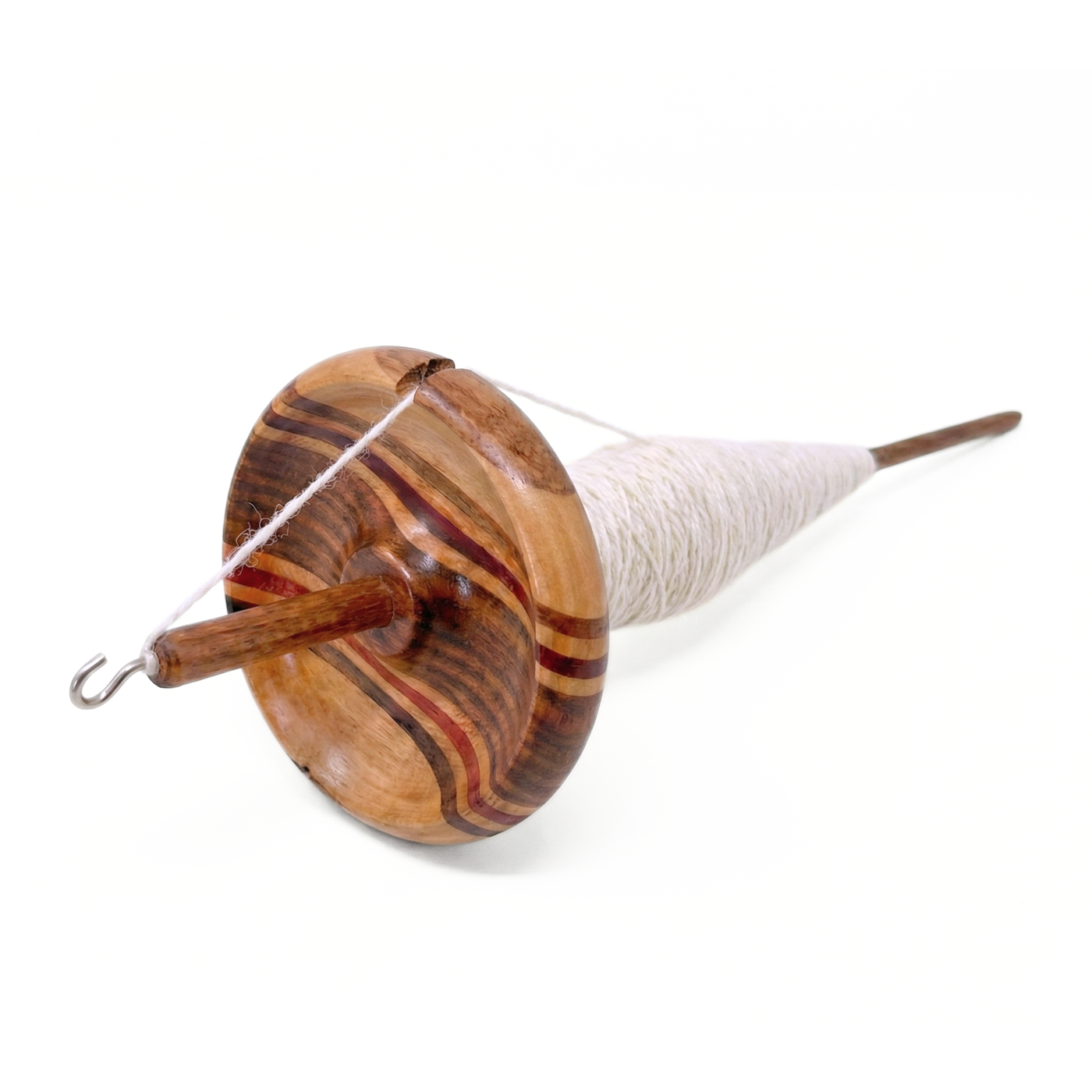 Top whorl drop spindle with freshly spun white singles yarn wound on the shaft under the whorl, multi-wood wavy whorl, white background