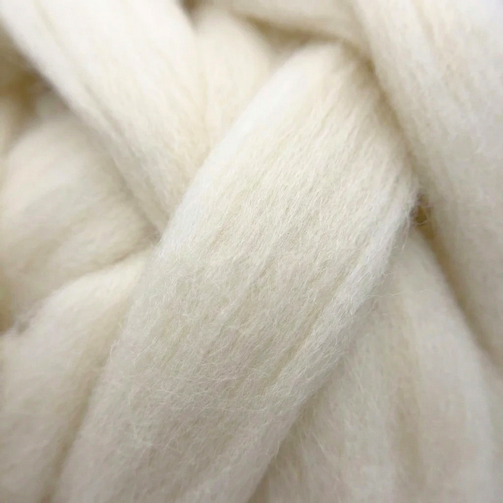 Macro close-up of undyed Cheviot combed wool top fibers showing aligned staple and smooth texture for spinning and felting.