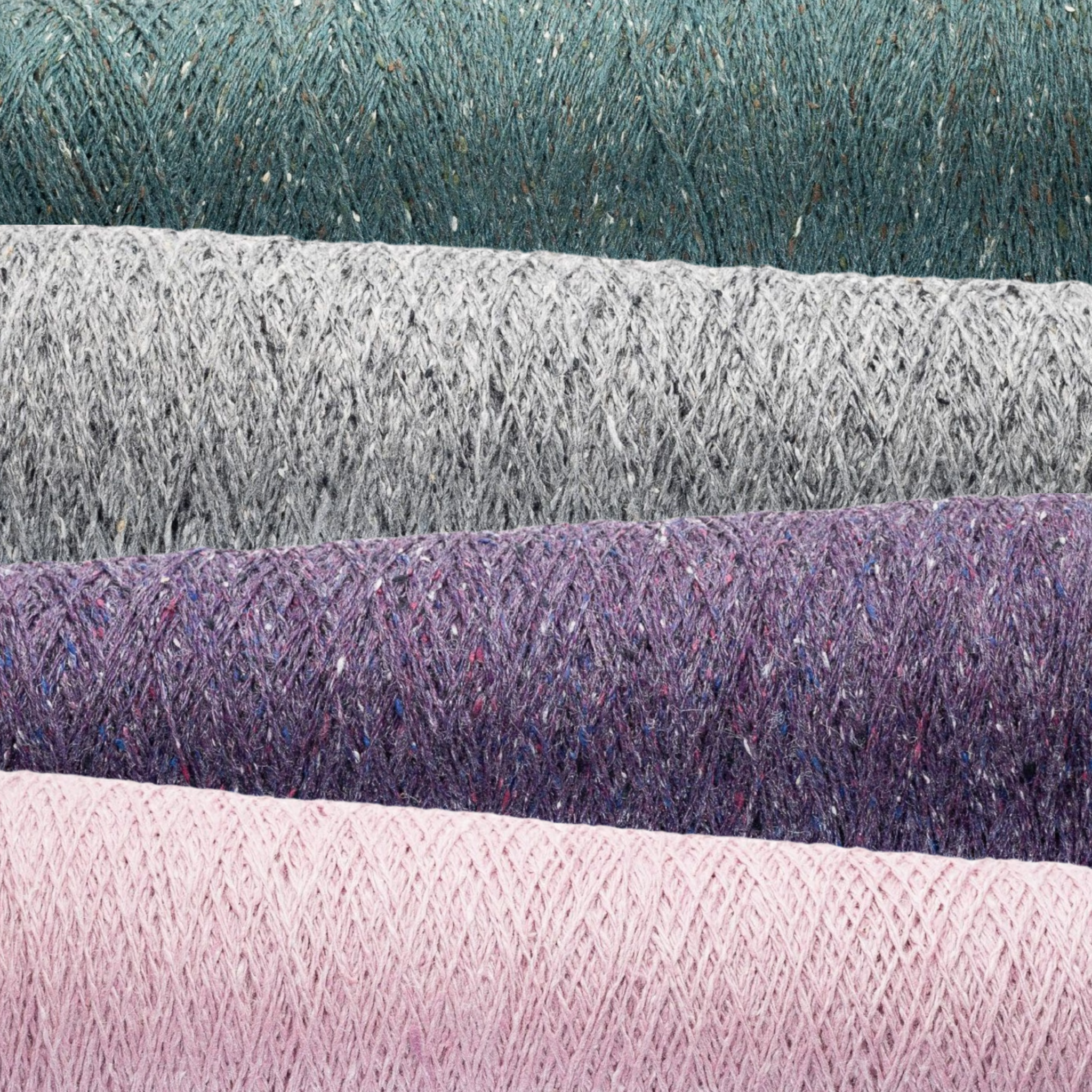 Close-up of Sero Silk Noil Weaving Yarn cones in Pool Green, Light Gray, Violet, and Cherry Blossom. Featuring a rustic texture, matte finish, and melange effect with flecks of contrasting colors, these yarns are perfect for weaving, knitting, and crocheting projects.